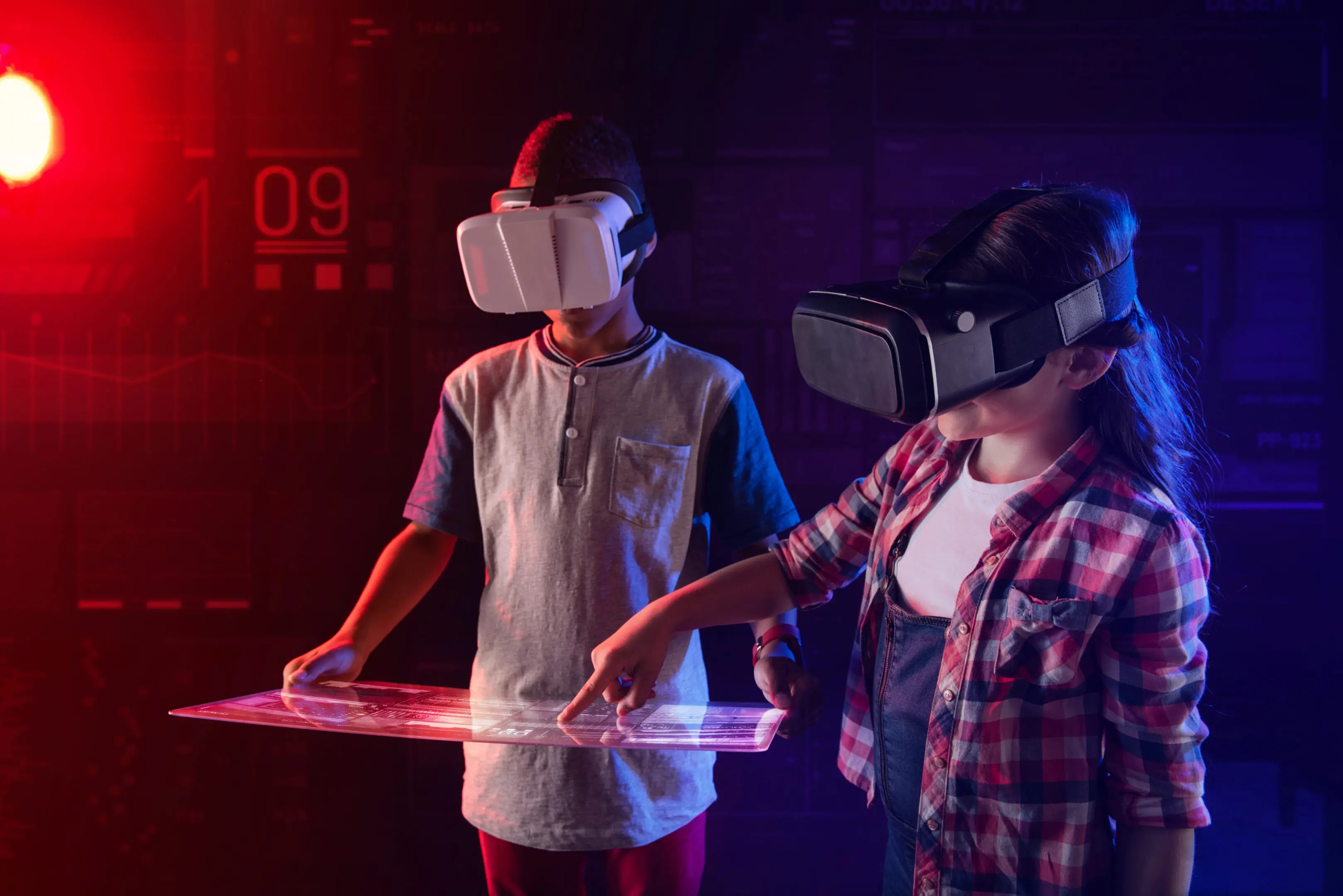 Easy usage. Concentrated modern kids wearing convenient virtual reality glasses and looking interested while learning how to use a futuristic transparent tablet